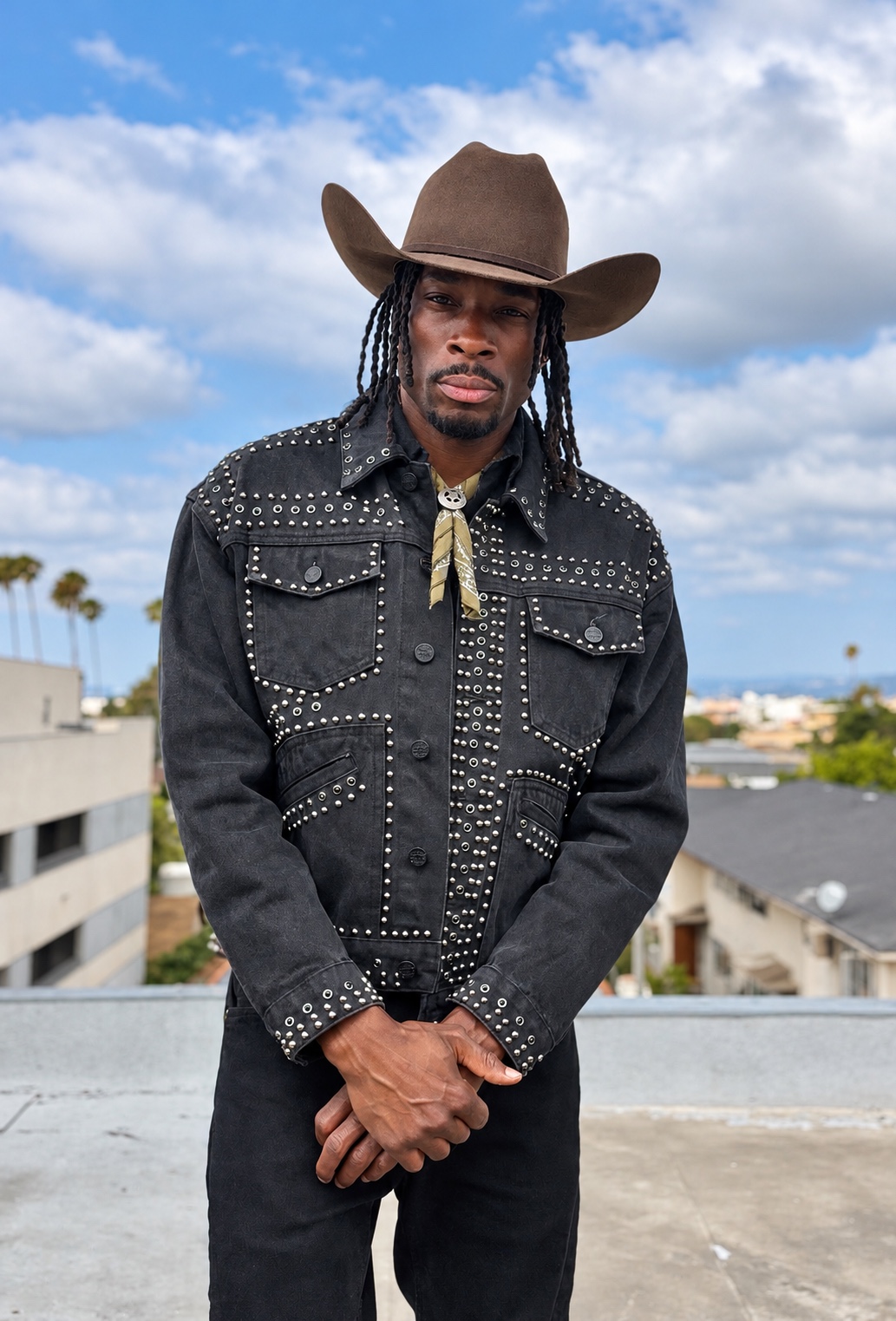 $ydney Mvrcus wearing a black cowboy hat and studded western jacket on a Los Angeles rooftop
